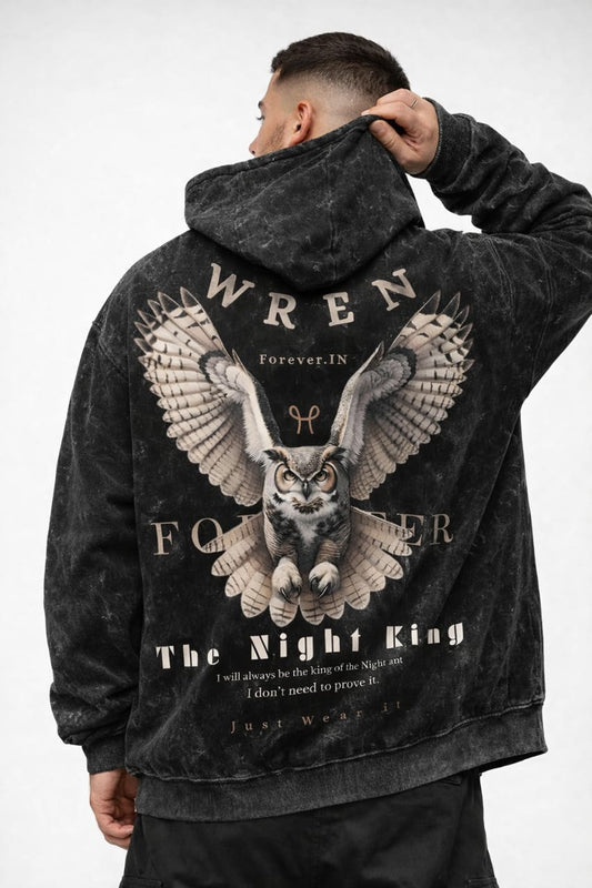 Person wearing a black hoodie with an owl graphic and text on the back, on a white background